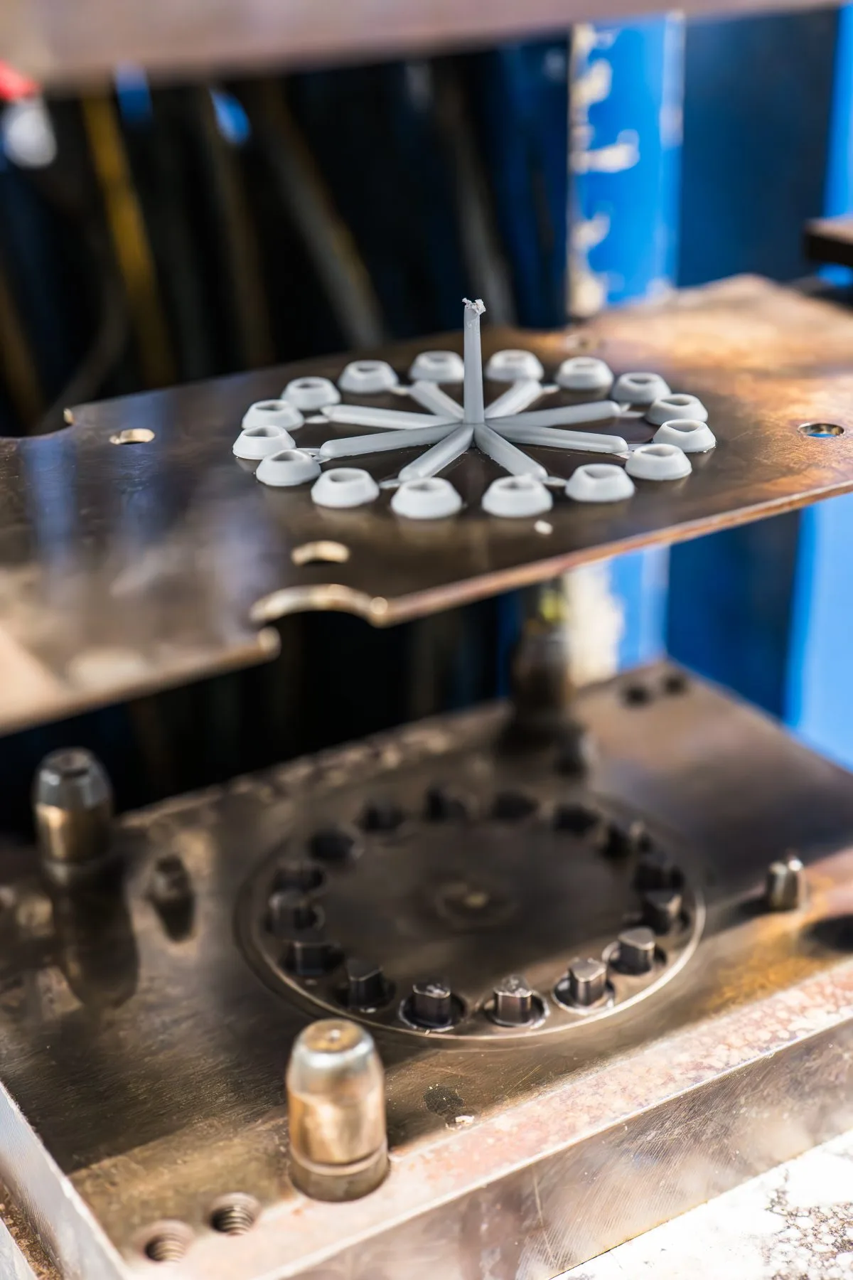 Open injection mould · star-shaped cavities with central runner and freshly ejected parts